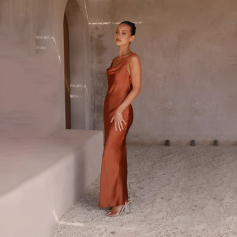 Copper satin one-shoulder evening gown featuring a fitted waistline and sleek silhouette, modeled by a fashion model.