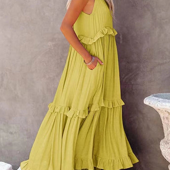 Coral backless halter maxi dress with tiered ruffles and boho summer style, featuring a flowing silhouette suitable for a casual or bridal party setting.
