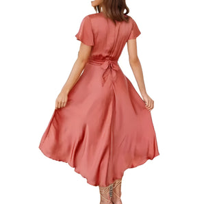 Coral satin midi dress featuring an A-line silhouette with a bow tie back, highlighting a fitted waist and elegant shoulder design, perfect for party occasions.