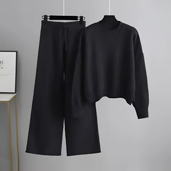 Black Cozy Cream Knit Sweater & Wide-Leg Pants Set on a clothes hanger, featuring long sleeves and a comfortable, loose fit.