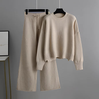 Cozy cream knit sweater with long sleeves and matching wide-leg pants set on a clothes hanger, showcased in a beige color, ideal for winter loungewear.