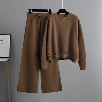 Cozy cream knit sweater with long sleeves and wide-leg pants set hanging on a clothes hanger in a neutral setting, showcasing winter loungewear.
