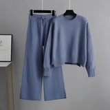 A cream-colored knit sweater and wide-leg pants set displayed on a clothes hanger, showcasing winter loungewear fashion.