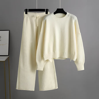 Cozy cream knit sweater and wide-leg pants set on a clothes hanger, featuring a round neck and long sleeves, perfect for winter loungewear.