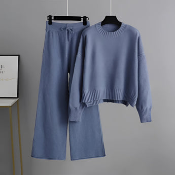 A blue cozy cream knit sweater and wide-leg pants set hanging on a clothes hanger, showcasing long sleeves and a comfortable, stylish winter loungewear design.