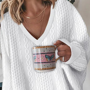 A woman's cozy white V-neck knit sweater with long sleeves, showcasing a comfortable and stylish fit, perfect for fall fashion.