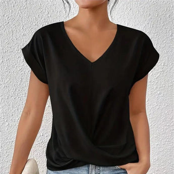 A woman wearing an elegant black short sleeve blouse paired with jeans, highlighting the blouse's stylish collar and comfortable fit.