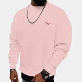 Men's crewneck sweatshirt in rose pink, featuring a minimalistic urban style with a small bird logo on the chest. Model is shown wearing the sweatshirt, highlighting the comfortable fit with long sleeves and a crew neckline. The 3XL size offers a relaxed and casual look.