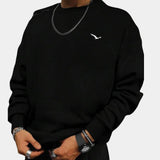 Black crewneck sweatshirt for men in minimalistic urban style featuring a subtle bird logo on the chest, shown in 3XL size, with long sleeves and a comfortable fit.