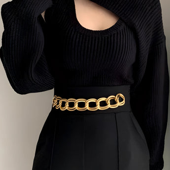 Black cutout ribbed knit sweater with puffed sleeves, featuring a trendy winter fashion style. The sweater has a high neckline and fitted waist, designed for a fashionable look. The image shows the sweater being worn, emphasizing its stylish design and comfortable fit.