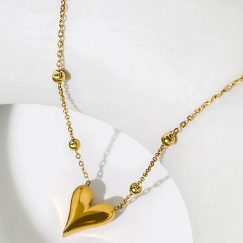 Dainty 18K gold heart pendant necklace featuring a delicate chain, designed as an elegant and romantic jewelry gift.