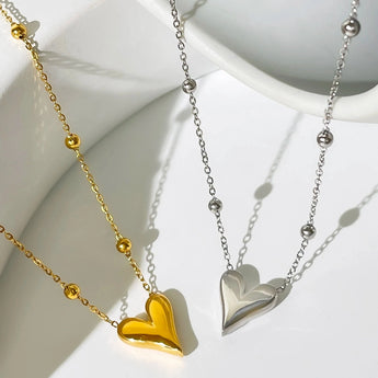 Dainty 18K gold heart pendant necklace on a delicate chain, shown against a neck, perfect as an elegant romantic jewelry gift.