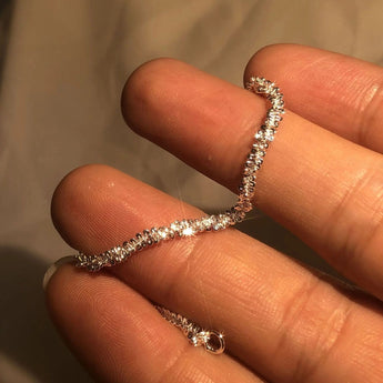 Elegant minimalist silver dainty diamond bracelet on a woman's wrist, perfect for bridal jewelry.