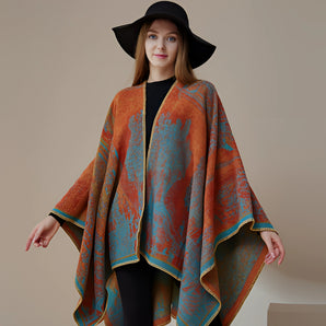 Designer wool poncho featuring an elegant bohemian style, worn by a smiling model with a fedora hat.