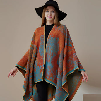 Designer wool poncho featuring an elegant bohemian style, worn by a smiling model with a fedora hat.