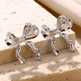 Artistic earrings featuring a combination of wood and silver in unique bound shapes, styled as a fashionable body jewelry accessory.