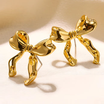Pale yellow gold earrings in bound shapes design, featuring intricate metalwork and artistic symbolism.