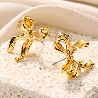 Gold earrings featuring intricate knot designs and feather details, suitable for special events or wedding ceremonies.