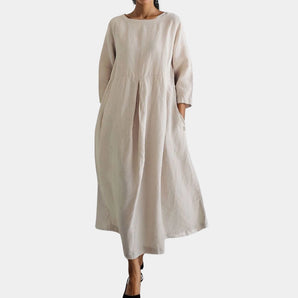Eco-friendly oatmeal linen maxi dress with a minimalist loose fit, featuring a modest neckline and relaxed sleeves, designed as a one-piece day dress with a defined waist.