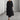 Eco-friendly oatmeal linen maxi dress in black with a minimalist loose fit design. The dress features a round neckline and long sleeves, extending to ankle length. Suitable for formal or casual occasions. Shown in size XL.