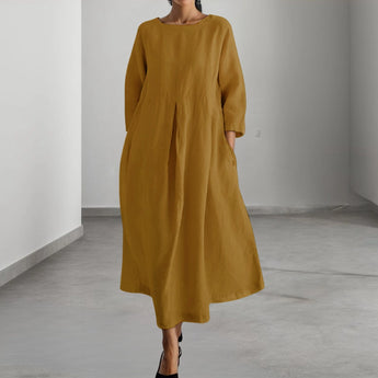 Eco-friendly oatmeal linen maxi dress in a yellow-brown color, featuring a minimalist loose fit style with a focus on comfort and fashion. The dress has a modest neckline, long sleeves, and falls elegantly to the knees, making it ideal for daytime wear. Designed for XL sizing, it complements both the waist and thigh areas.