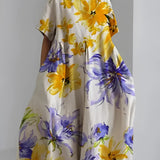 Eco-friendly oversized floral dress featuring a white base with green leaf print and yellow accents, designed in a 4XL size. The dress has a one-piece garment style with sleeves and a defined waist, perfect for daytime wear.