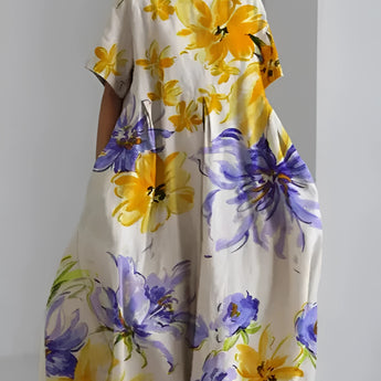 Eco-friendly oversized floral dress featuring a white base with green leaf print and yellow accents, designed in a 4XL size. The dress has a one-piece garment style with sleeves and a defined waist, perfect for daytime wear.