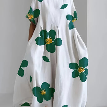Oversized floral dress in white with green leaf print, featuring short sleeves and a round neckline, available in size 4XL.