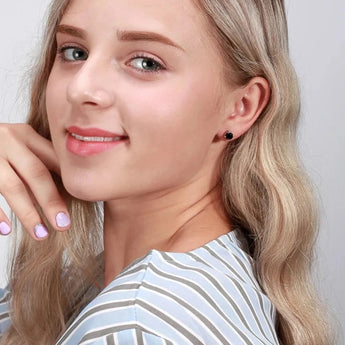 Close-up of a woman's face featuring Effie Queen Black Cubic Zirconia 925 Sterling Silver Stud Earrings.