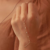 Elegant 18K gold adjustable anklet worn on a woman's ankle, showcasing dainty summertime jewelry in a stylish and subtle manner.
