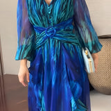 Elegant 2024 Women's Chiffon Maxi Dress in blue-green with sheer sleeves; features a wrap design and flowing one-piece silhouette.