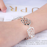 A hand wearing an elegant 925 sterling silver geometric bracelet with an adjustable clasp around the wrist.