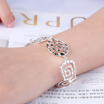 A hand wearing an elegant 925 sterling silver geometric bracelet with an adjustable clasp around the wrist.