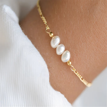 Elegant adjustable gold bracelet adorned with a single pearl, designed as a luxury jewelry gift for her.