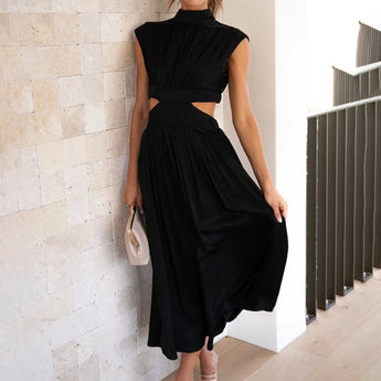 Elegant black midi dress with a back cutout, featuring a fitted waist and knee-length hem. The dress has a stylish one-piece design suitable for evening wear.