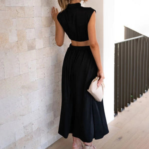 
A woman wearing an elegant black midi dress with a back cutout, featuring a fitted waist, short sleeves, and a modest neckline. The dress has a sophisticated and stylish design, suitable for evening wear.