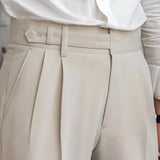 Elegant beige high-waisted pleated trousers worn with a white dress shirt, showcasing a sophisticated women's office wear look.