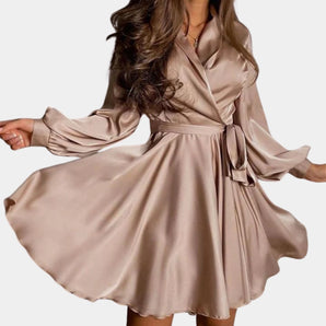 Elegant beige satin wrap dress with long sleeves and a mini length, styled for a party setting, shown in khaki color in size XL.
