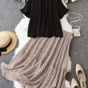 Elegant black blouse paired with a floral skirt, showcasing a women's casual summer outfit.