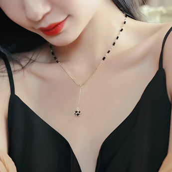 Elegant black gemstone pendant necklace with gold chain displayed on a woman's neck, showcasing luxury women's jewelry.