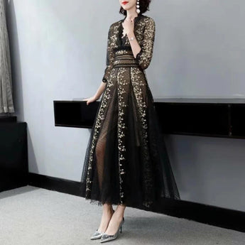 Elegant black and gold embroidered lace evening gown maxi dress with long sleeves and a fitted waist, showcasing intricate fashion design elements.