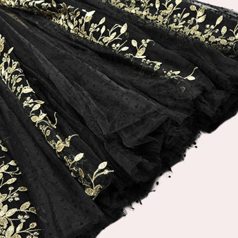 Elegant black and gold evening gown with intricate embroidered lace details, featuring long sleeves and a fitted waist, styled as a maxi dress.