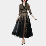 Elegant black and gold embroidered lace evening gown maxi dress featuring intricate embellishments, fitted waist, and long sleeves, styled on a fashion model.