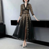 Elegant black and gold embroidered lace evening gown maxi dress featuring intricate detailing on the waist, long sleeves, and a sophisticated neckline.