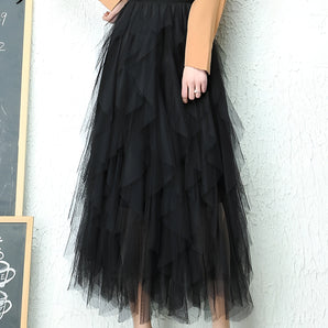 Elegant black layered tulle midi skirt for formal occasions, featuring a soft, flowing fabric with a flattering waistline that drapes elegantly over the legs.