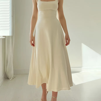 Elegant black midi dress with a square neckline and pockets, featuring a fitted bodice and flowing skirt.