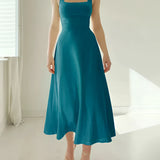 Elegant black midi dress with a square neckline, showcasing short sleeves and functional pockets.