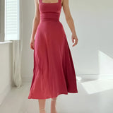 Elegant black midi dress with a square neckline and pockets, suitable for both casual and formal occasions.