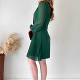 Elegant black pleated mini dress with long sleeves, featuring a chic office-ready style.
