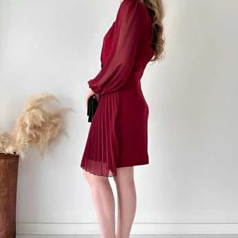 Elegant black pleated long sleeve mini dress featuring a fitted waist and knee-length hem, perfect for an office chic look.